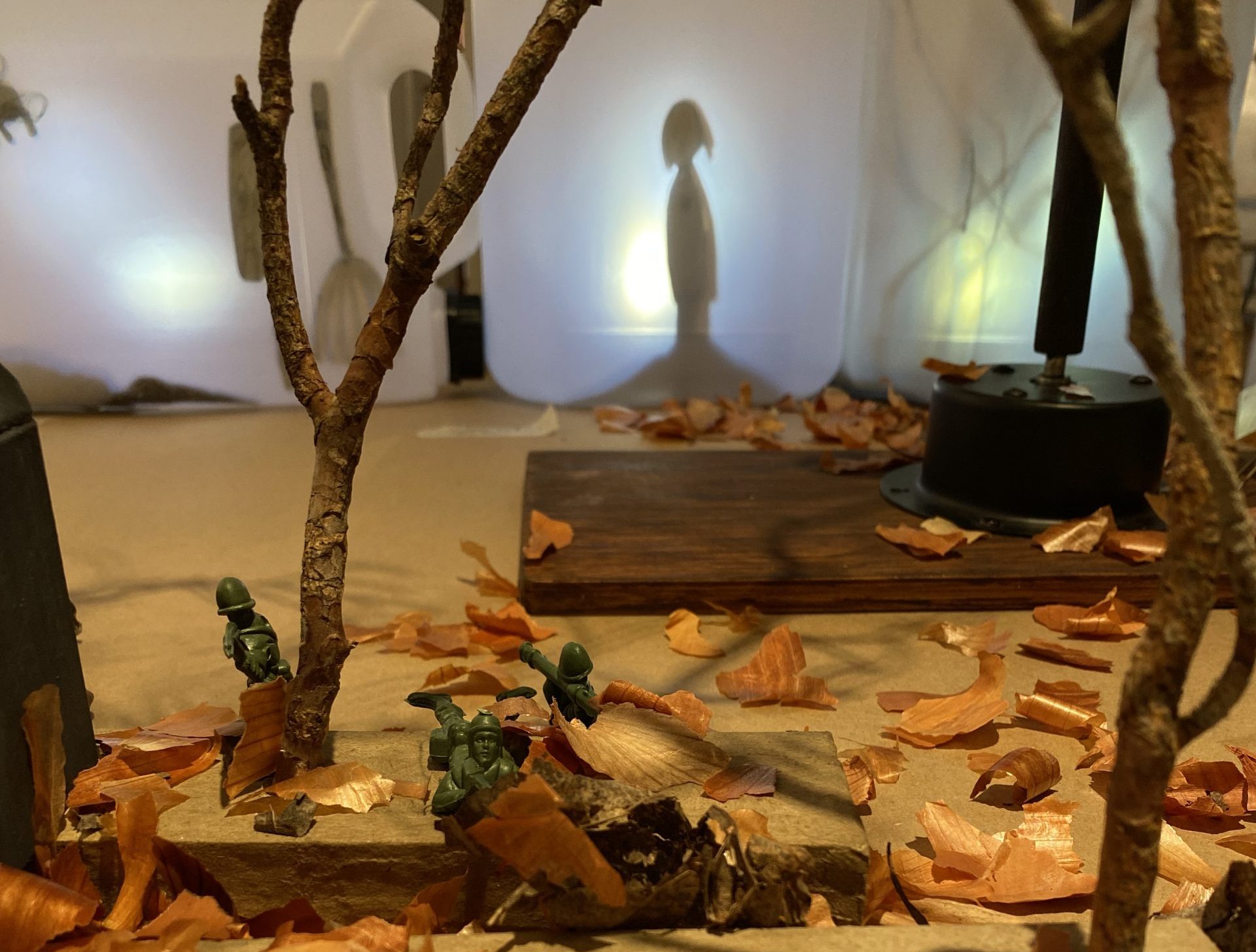 små figurer og skyggen av en skikkelse